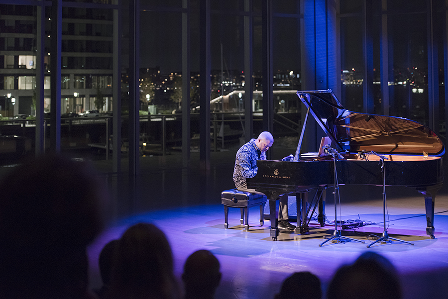 Jason Moran playing the piano in the ICA theater, overlooking the harbor.