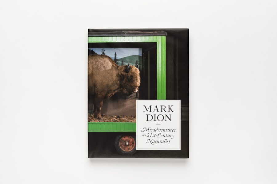 The image shows the cover of a book titled Mark Dion: Misadventures of a 21st-Century Naturalist. The cover features an artwork of a bison in a green structure resembling a vintage display cabinet on wheels.